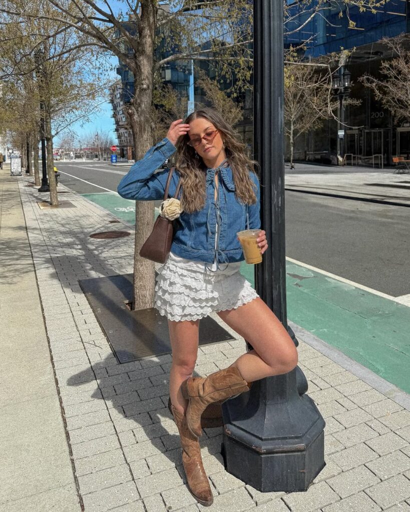 Mulher jovem usado blusa jeans de manga longa, saia com babados branca e bota de cowboy marrom