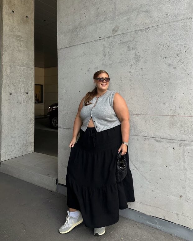 Mulher jovem usando colete, saia longa e tênis