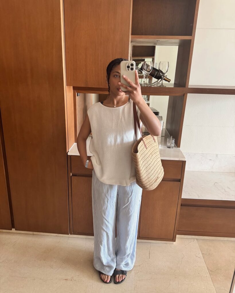 muher jovem com blusa clara e calça listrada