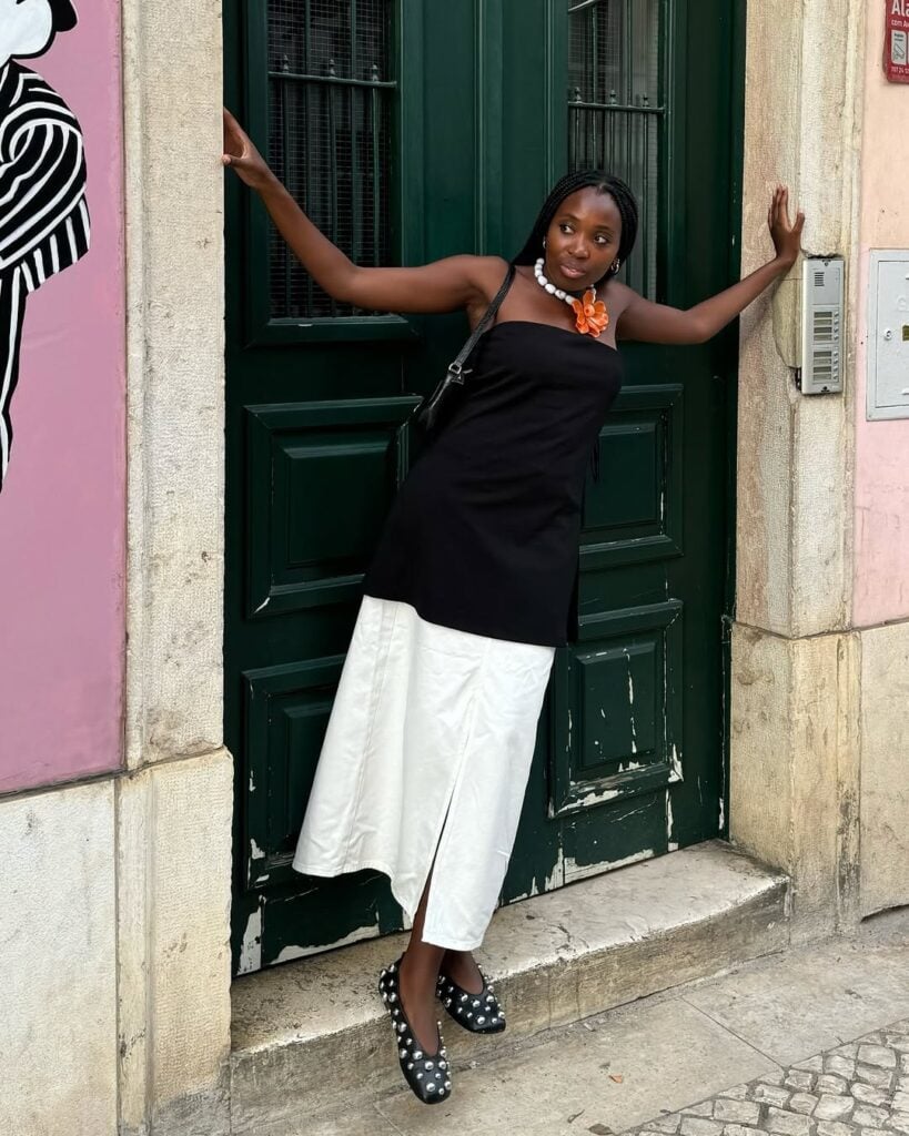 mulher jovem com roupa preto e branco e sapatilha preta