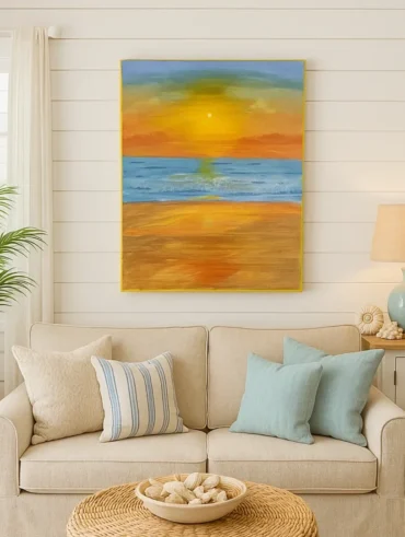 Sala de estar com sofá bege, almofadas em azul-claro, quadro com paisagem de praia na parede