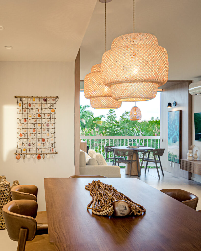 Mesa de jantar de madeira e luminárias de fibras naturais acima