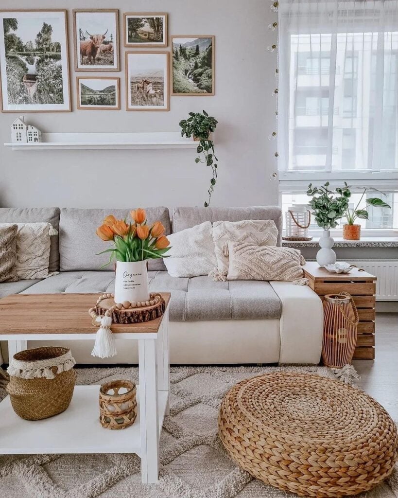 Sala em tons neutros com itens de vime, mesa lateral de madeira e vaso com tulipas