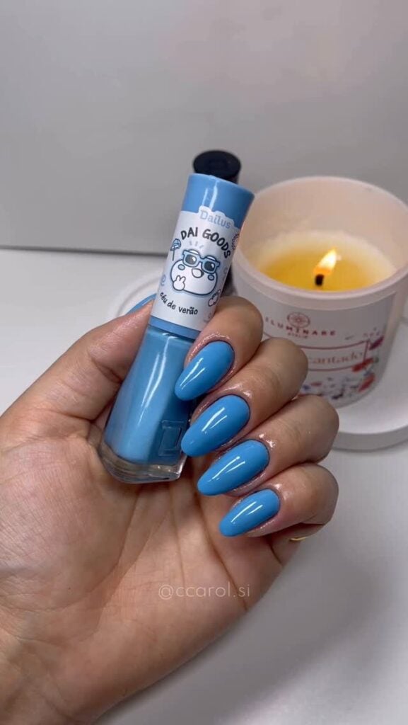 Mão de pele clara, com unha azul glacial