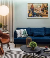 Sala de estar com tapete listrado, mesas de centro e sofá azul-marinho em veludo
