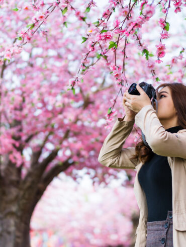 Mulher de cabelo comprido com uma câmera fotográfica na mão
