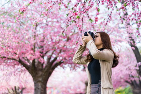 Mulher de cabelo comprido com uma câmera fotográfica na mão