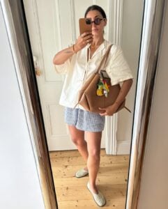 Mulher de pele clara, com blusa branca, short e sapatilha telada