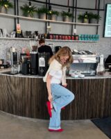 Mulher de pele clara, com blusa branca, jeans e sapato Mary Jane