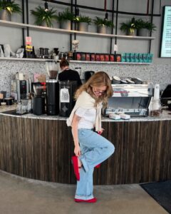 Mulher de pele clara, com blusa branca, jeans e sapato Mary Jane