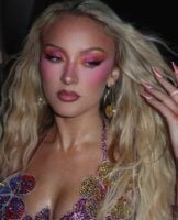 Zara Larsson com cabelo loiro e maquiagem colorida