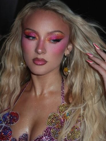 Zara Larsson com cabelo loiro e maquiagem colorida