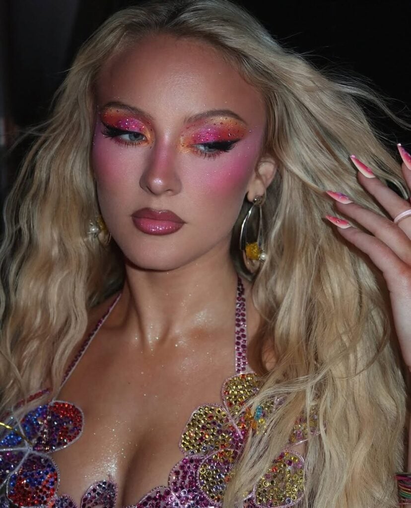Zara Larsson com cabelo loiro e maquiagem colorida