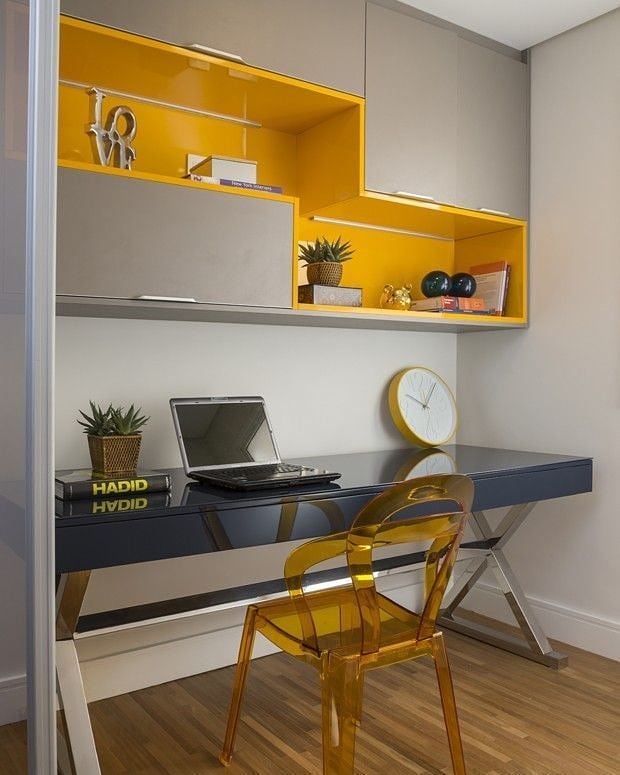 Bancada de trabalho azul-marinho e armário aéreo com marcenaria colorida em cinza e amarelo