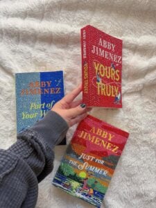 Capas de livros da Abby Jimenez em cima da cama
