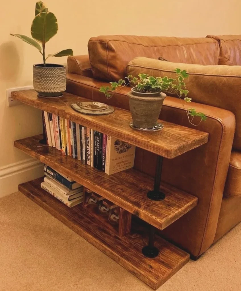 Sofá de couro marrom mesa lateral de madeira rústica com livros e vaso de plantas