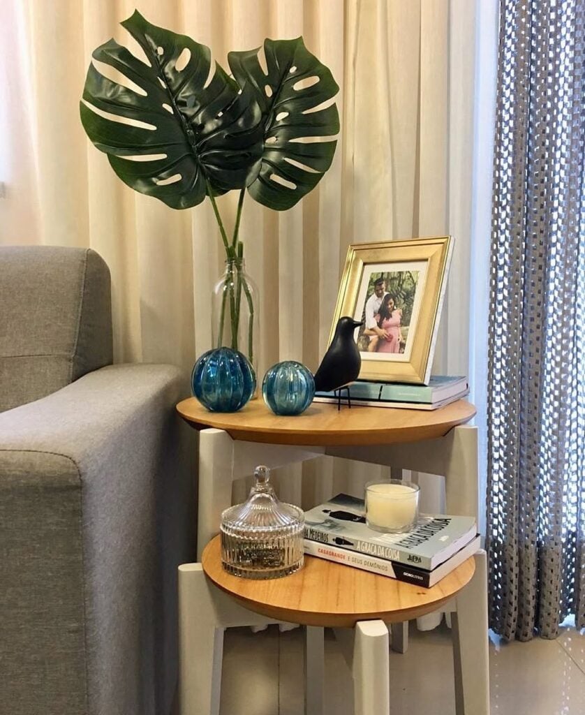 Conjunto de mesas laterais com tampo de madeira e objetos decorativos