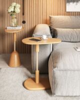 Sofá cinza com mesas laterais em formato orgânico com objetos decorativos