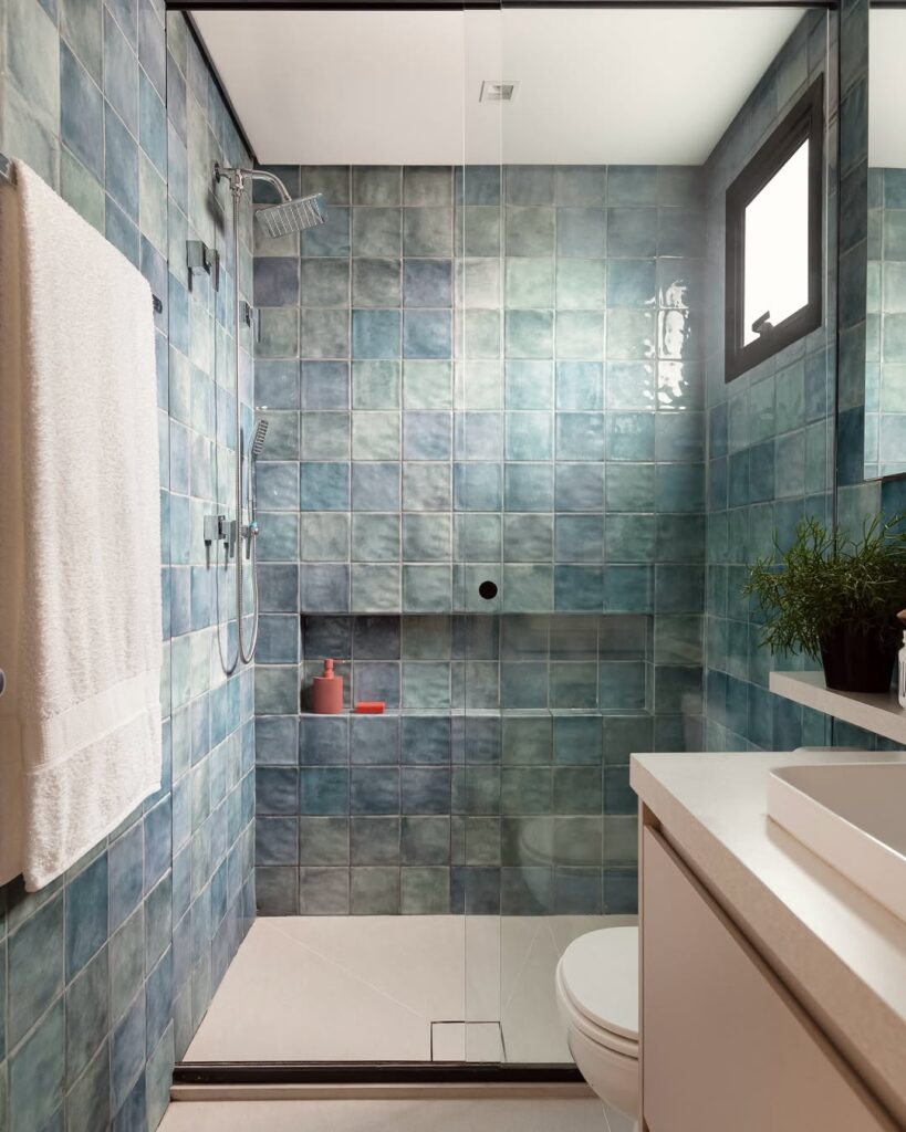 Banheiro com revestimento azul e nicho embutido do mesmo material