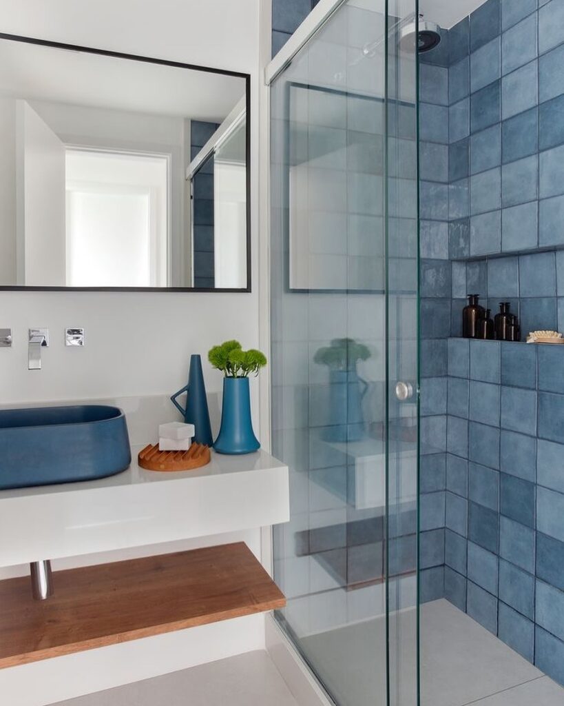 Banheiro branco e azul com box de vidro