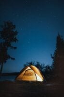 Céu noturno com estrelas e barraca com iluminação
