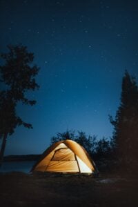 Céu noturno com estrelas e barraca com iluminação