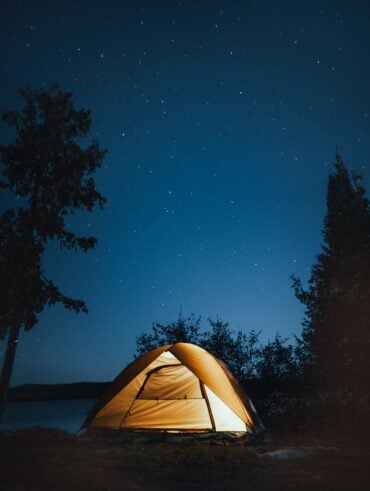 Céu noturno com estrelas e barraca com iluminação