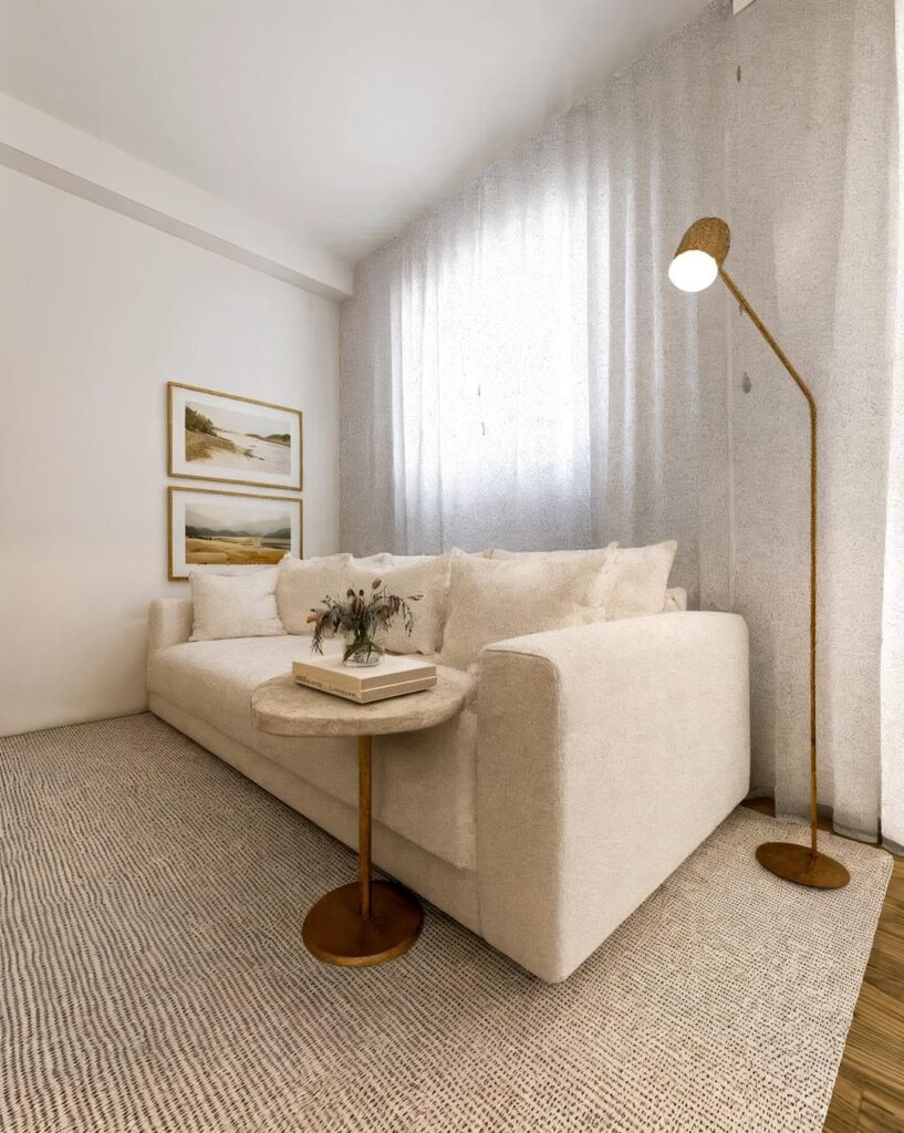 Sala de estar com sofá off-white, luminária de piso e grande tapete