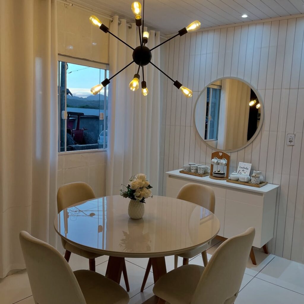 Sala de jantar com mesa redonda e luminárias com várias lâmpadas
