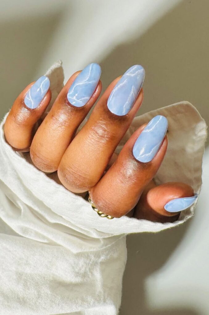 Unha azul e delicada em mão de pele negra