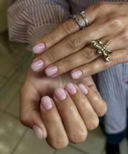 Mão de pele branca com esmalte de gel rosado