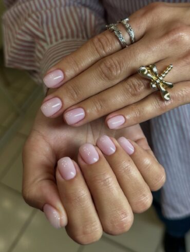 Mão de pele branca com esmalte de gel rosado