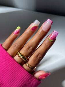 Mão de pele clara, com anéis e unha quadrada decorada