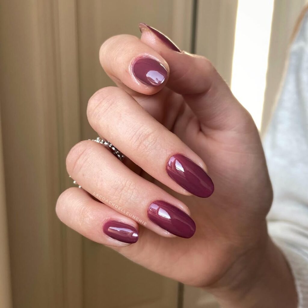 Mão de pele clara, com unha amendoada marsala