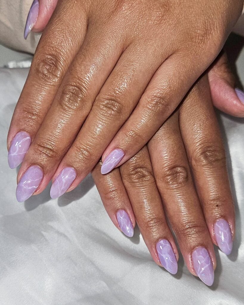 Mão de pele negra com unhas lilás