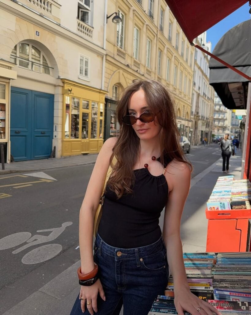 mulher jovem e magra de pele clara com blusa com um ombro só