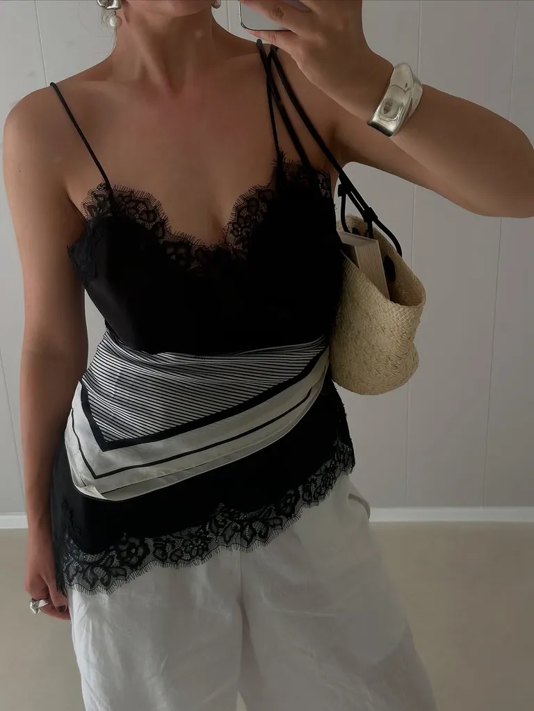 foto no espelho de mulher com blusa de cetim com lenço na cintura