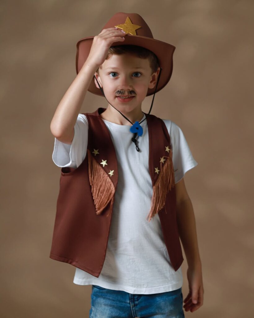 menino com chapéu e colete de cowboy e blusa branca