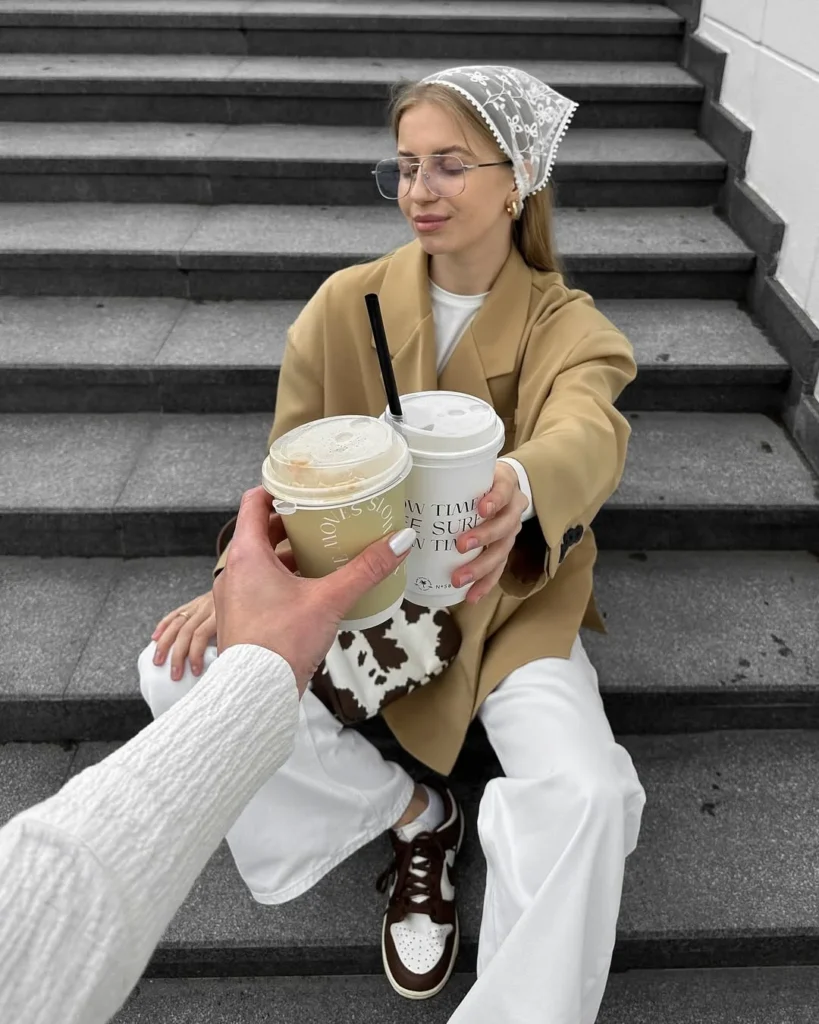 mulher jovem e magra com blazer, lenço de renda, calça branca e tênis nike
