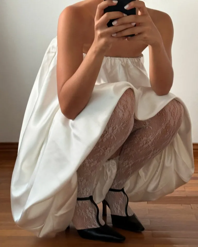 look com vestido branco e meia-calça de renda com sapato preto de bico fino