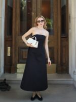 mulher jovem magra e de pele clara com vestido preto longo sem alças
