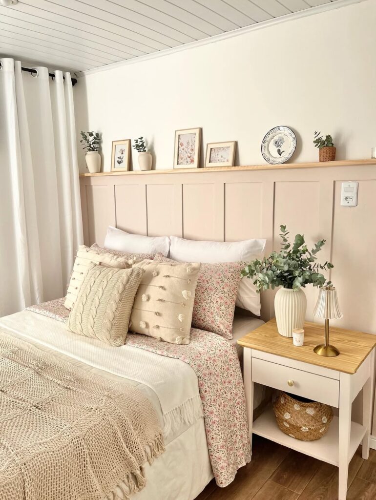Quarto em tons claros com mesa de cabeceira branca e camadas de texturas nas mantas e almofadas