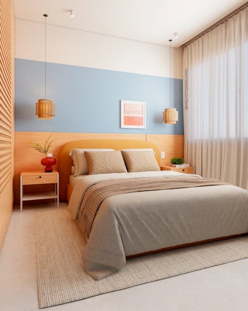 Quarto de casal com parte da parede em azul-claro com um quadro de bordas brancas