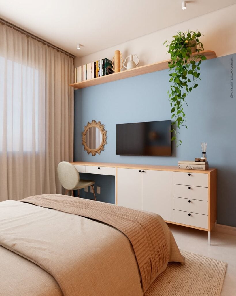 Quarto com bancada e escrivaninha na parede azul posterior à cabeceira