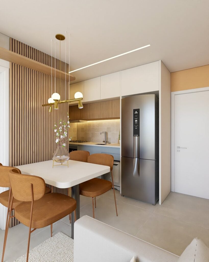 Apartamento pequeno em tons claros, com painel ripado ao lado da mesa de jantar e armário da pia azul