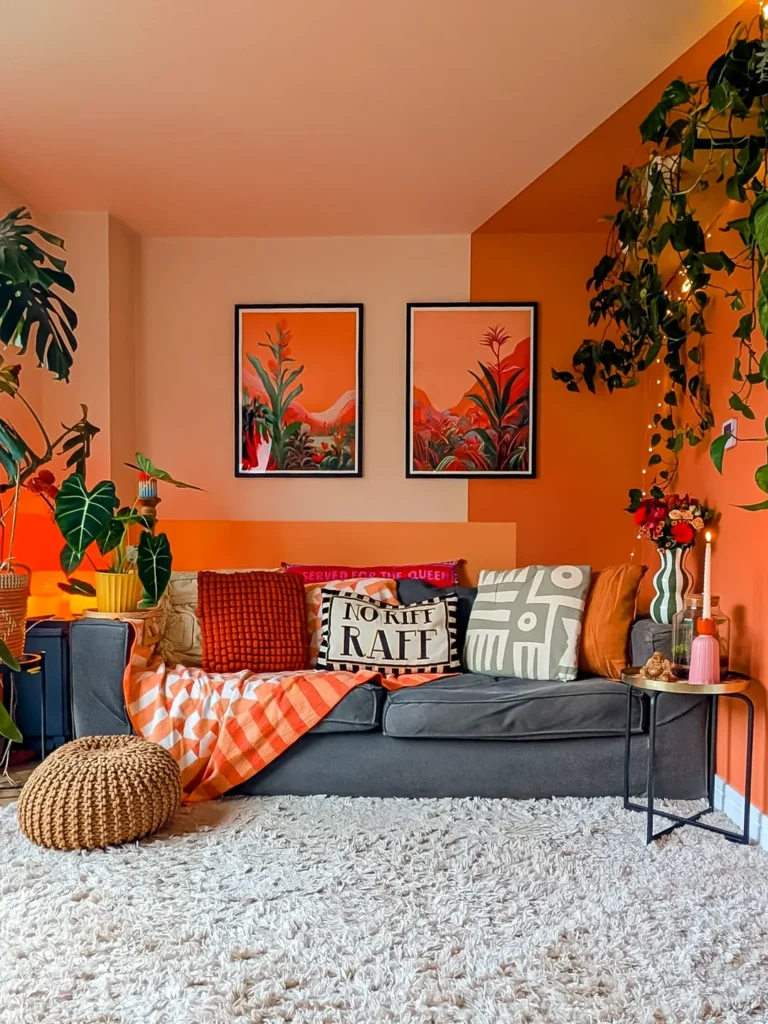 Sala de tv com sofá cinza, almofadas variadas, paredes e teto laranja e rosado