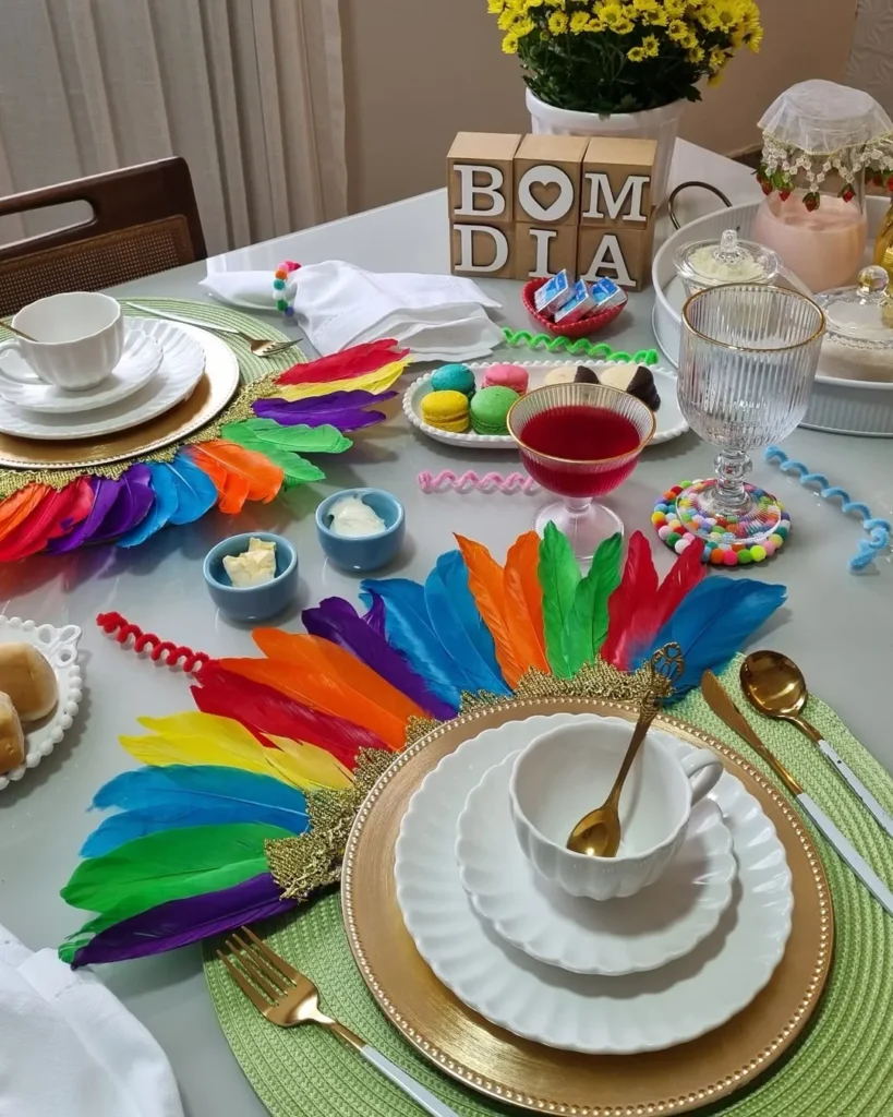 Mesa posta em clima de carnaval com item decorativo com penas coloridas