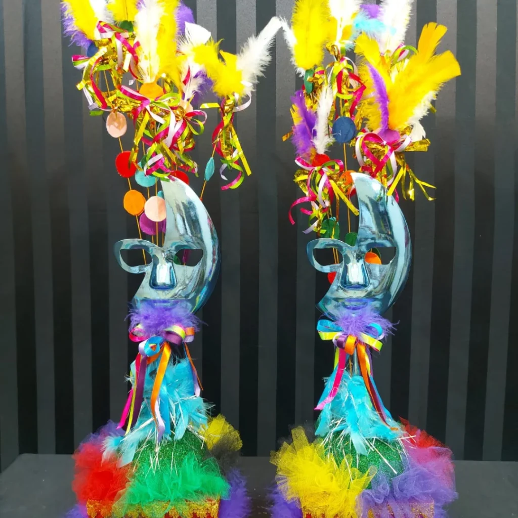 Centro de mesa carnavalesco com máscara metalizada azul, plumas e cores