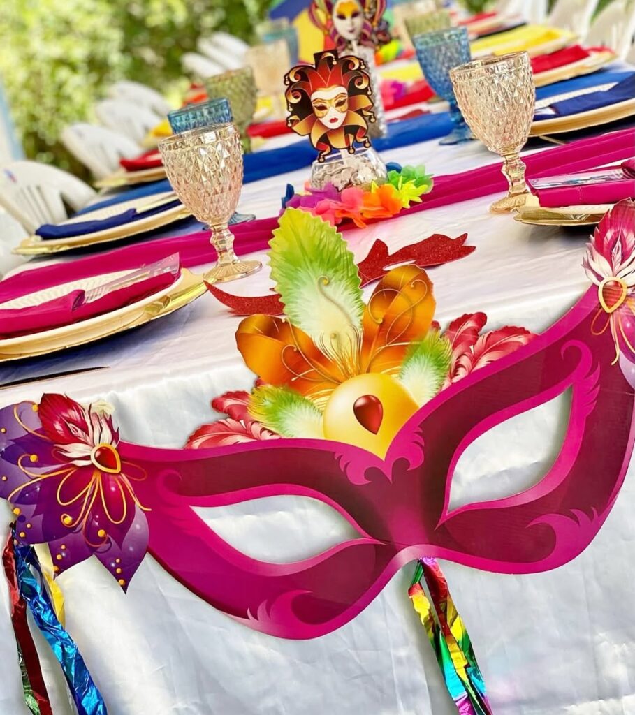 Mesa temática de Carnaval com copos e guardanapos coloridos e máscaras decorativas