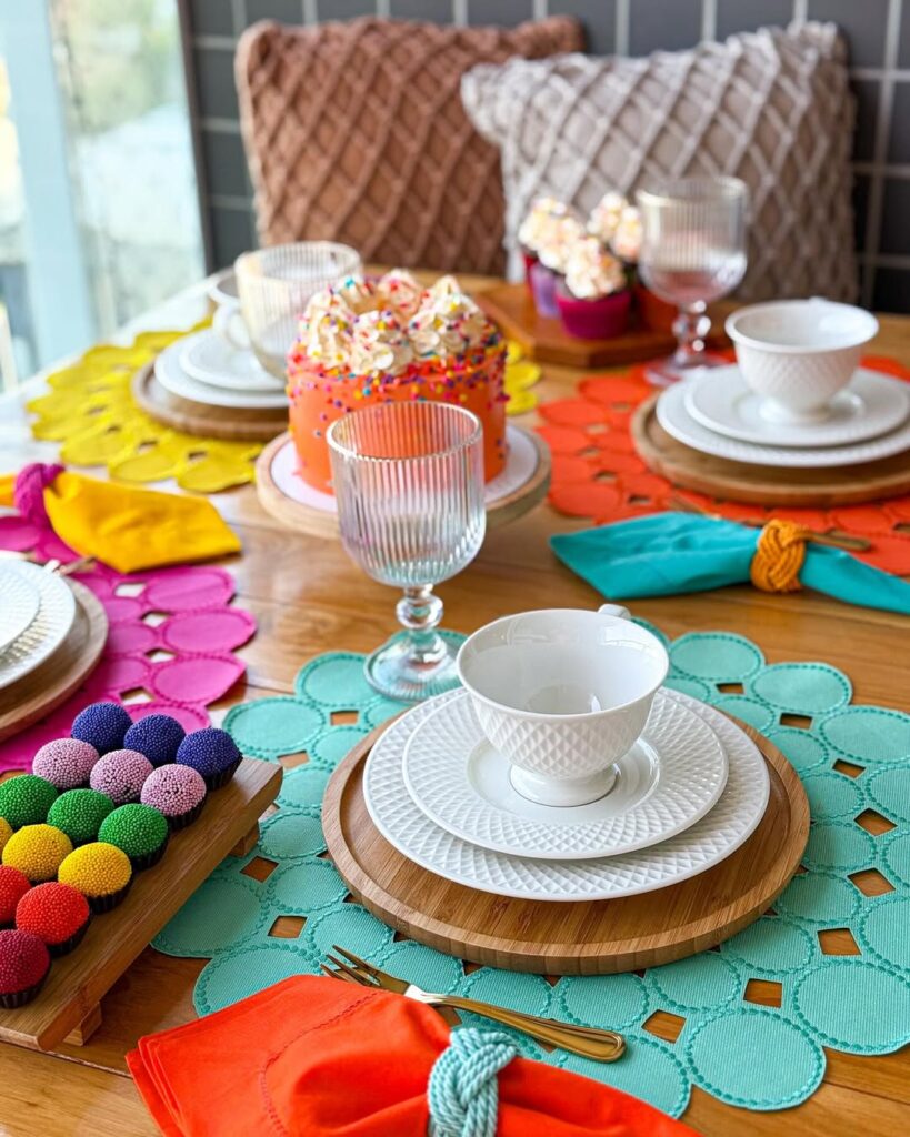 Mesa posta de café carnavalesco com sousplats e docinhos coloridos